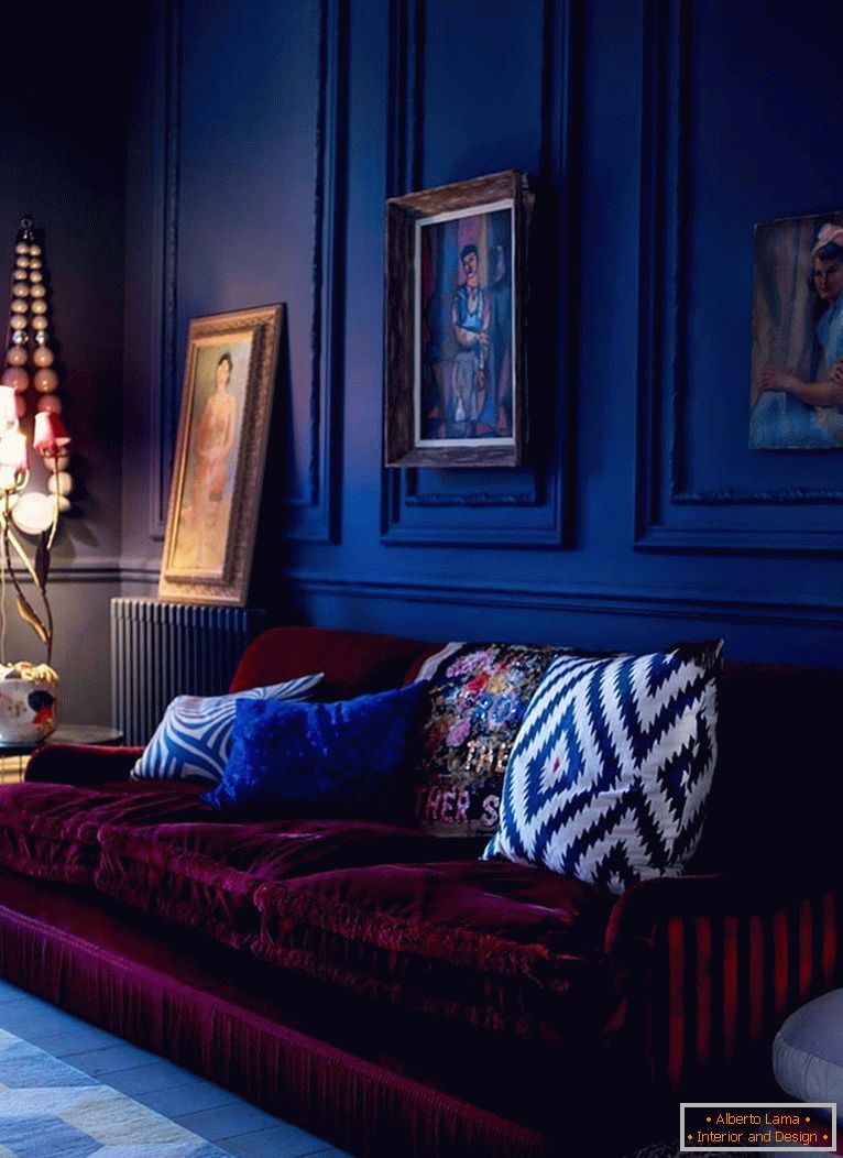 Bordo kavč na ozadju temno modrih sten