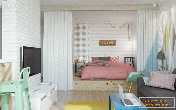 Skandinavski slog je idealen, če govorimo o oblikovanju majhnega stanovanja. V niši se nahaja spalnica z veliko mehko posteljo.