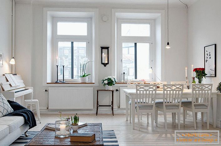 Elegantna dnevna soba je razdeljena na sedežno površino in jedilnico. V skladu s skandinavskim slogom so stene prostora bele barve.