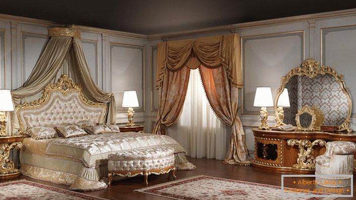 Ogledalo za veliko spalnico je pravilno izbrano. Oblika narobe ovalne oblike je odlična v okviru zlatega izrezljanega lesa.