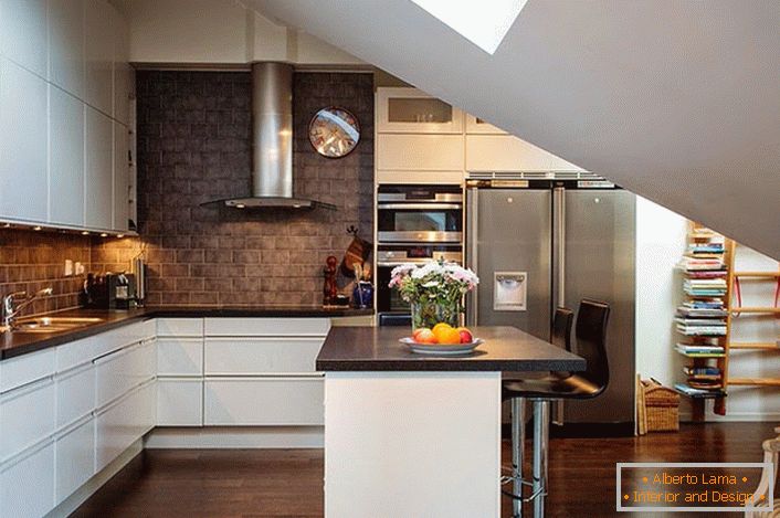 Kuhinja na podstrešju je urejena v skandinavskem slogu. Bele kuhinjske garniture dobro izgledajo ob stenah temnih opek. 