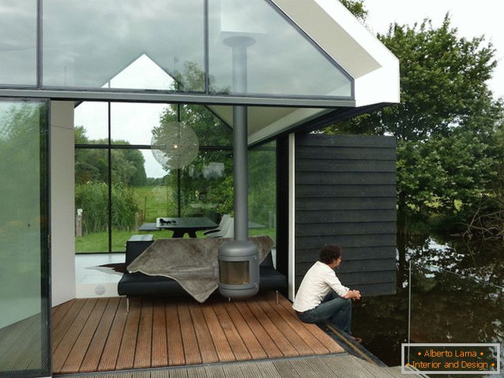 Terasa majhne steklene hiše ob jezeru na Nizozemskem
