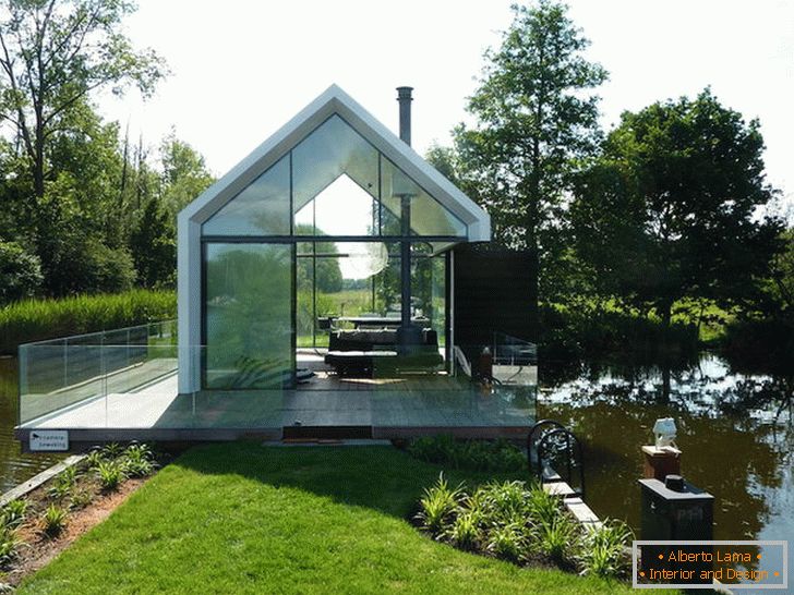 Mala steklena hiša v bližini jezera na Nizozemskem