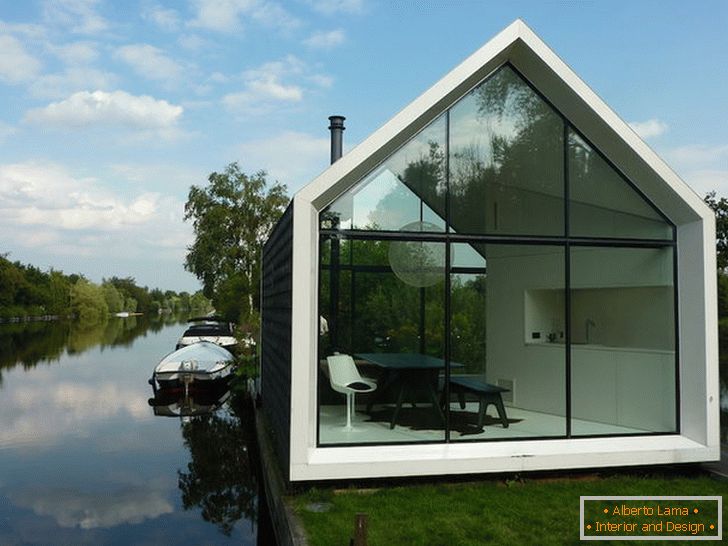 Mala steklena hiša v bližini jezera na Nizozemskem