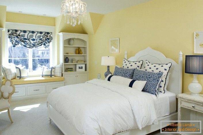 Bledo rumena barva konca harmonizira z belimi in modrimi elementi dekorja. Nenavadna kombinacija je krepko rešitev za spalnico v slogu države.