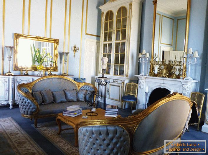 Dnevna soba v slogu Empire je izdelana v mehkih modrih barvah, ki se harmonično mešajo z zlatim elementom dekorja. Okvirje ogledal in rezbareni pohištveni elementi so izdelani v enoten slog.