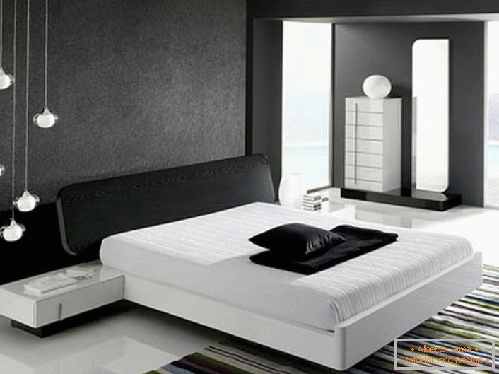 Stena na glavi postelje, okrašena s sivim mat vložkom, v skladu s slogom hi-tech je v harmoniji s sijajno belo tla.