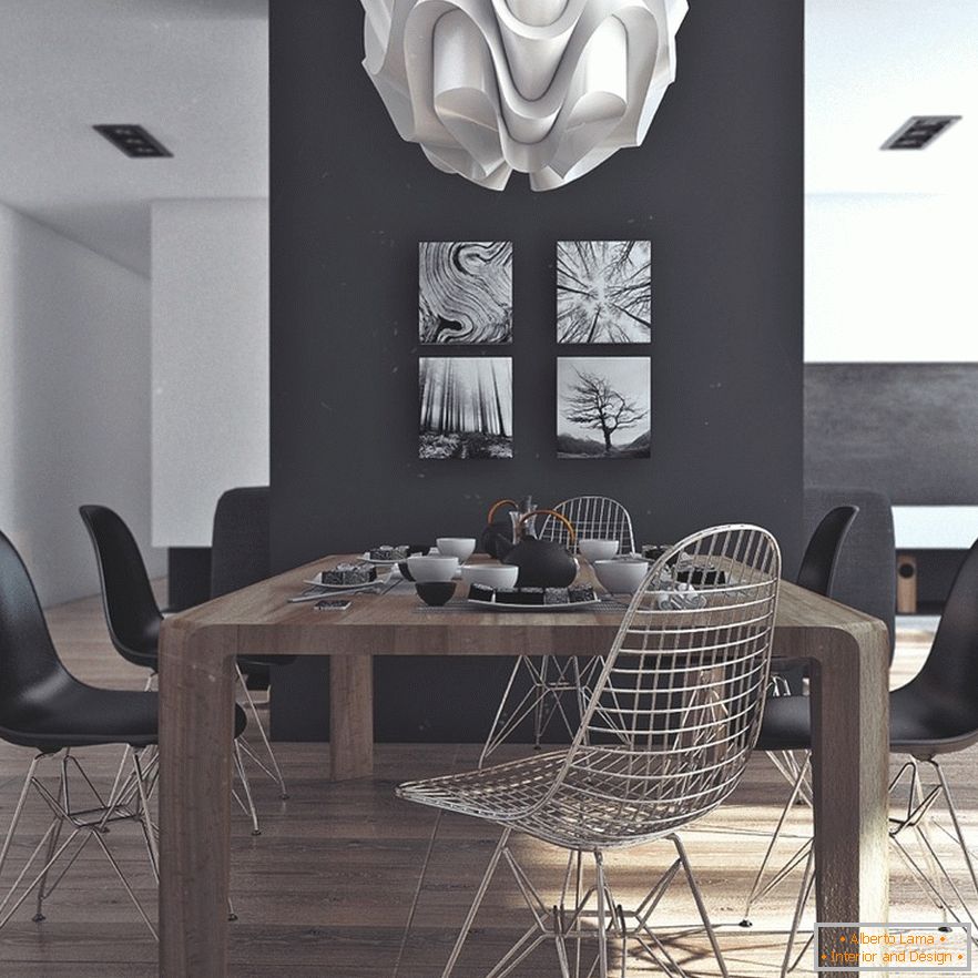Lesena jedilna miza, črni stoli in izvirne slike na črni steni