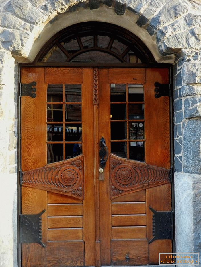 Vrata v slogu Art Nouveau okrasijo vhodna vrata dežele koči s fasado iz naravnega kamna. 