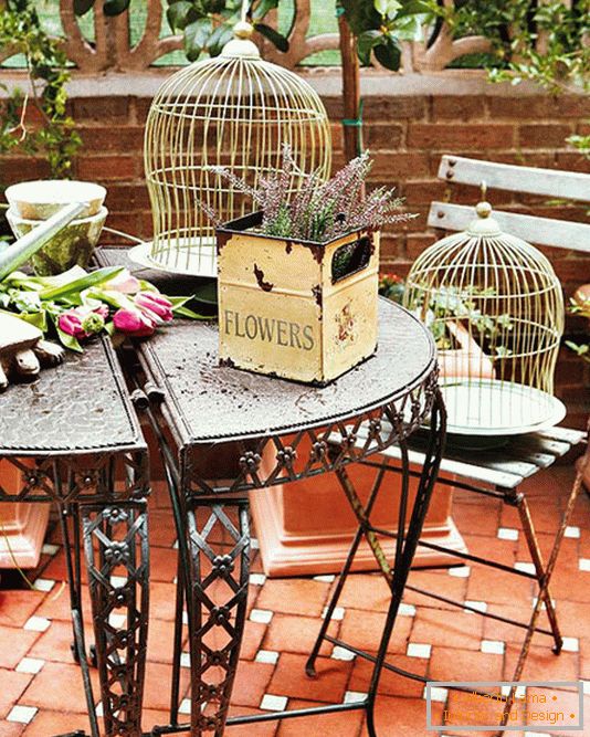 Kovana miza, škatle s cvetjem in kletkami za ptice