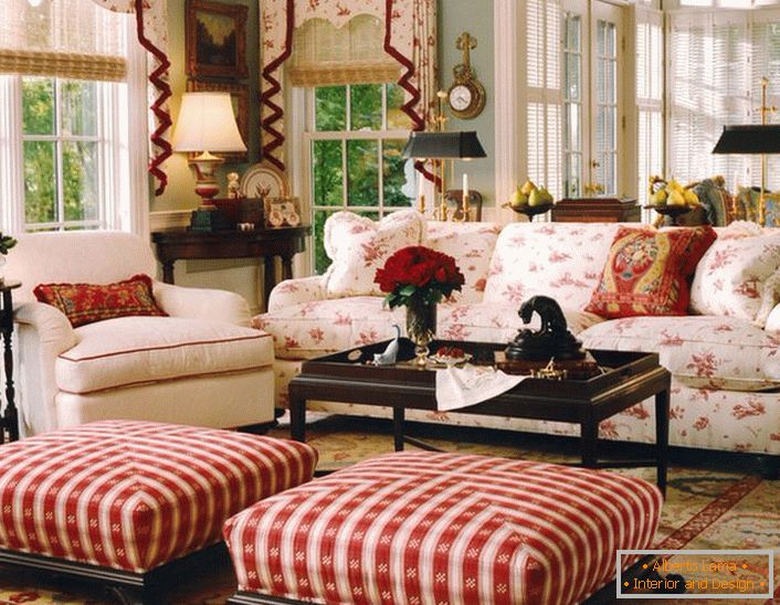 Preprosta, skromna in prijetna dnevna soba v angleškem slogu v majhni hiši. Rdeči poudarki omogočajo sproščeno in veselo atmosfero v prostoru.
