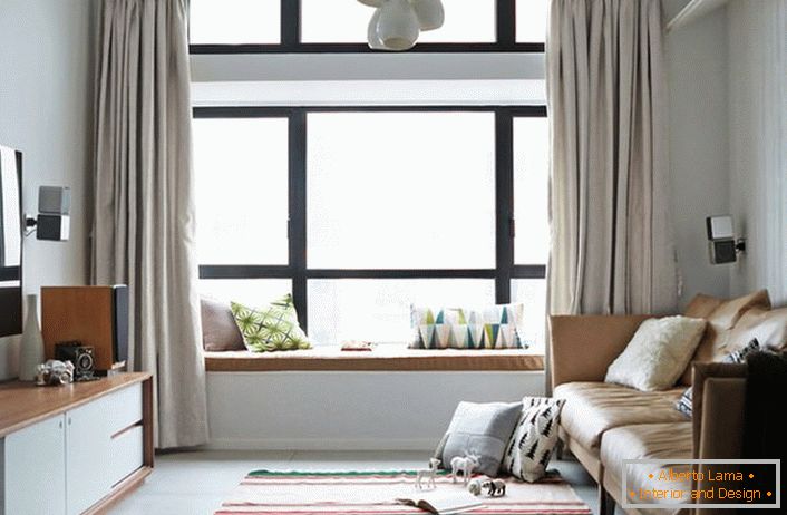 Enostavne enobarvne zavese mirnih svetlih barv so idealne za prostorno okno, razdeljeno na dele. Soba v skandinavskem slogu za mladega človeka, katerega svet glasbe in računalnika. 