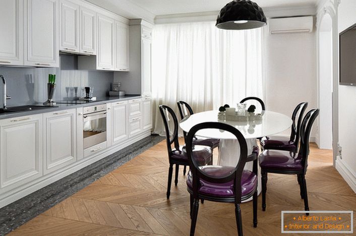 Bela notranja kuhinja z naglasi temno sive v eklektičnem slogu. Zanimivi stoli s prozornimi hrbtami in vijolično mehko oblazinjenje.