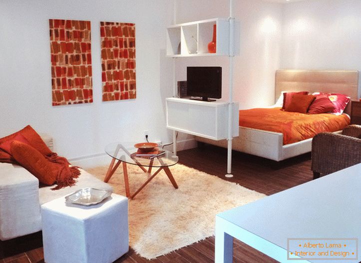 Notranjost bela studio apartma z oranžnimi poudarki