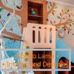 Otroška soba z visečo mrežo in drevo na steni