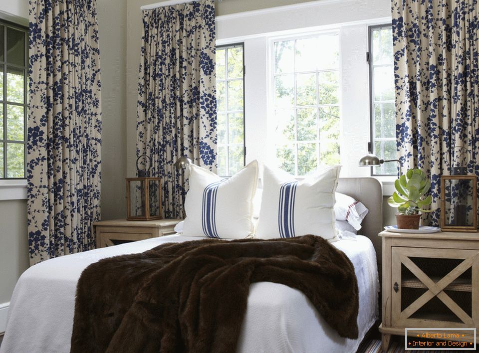 Modre cvetice na zavesah in stezah na blazinah so harmonično združene v notranjosti spalnice