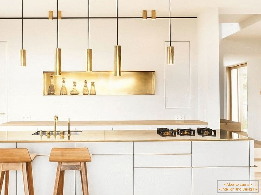 Elementi zlate dekoracije v beli kuhinji z lesenimi barskimi blazinicami
