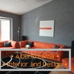 Oranžno pohištvo v sivi sobi