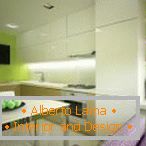 Belo pohištvo in svetlo zelene stene v kuhinji