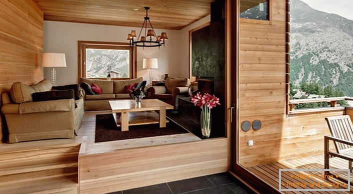 Podstrešje tla vile z dostopom do verande je urejeno v slogu koče. Barva svetlega lesa izgleda dobičkonosna v kombinaciji s temno rjavo talno ploščico.