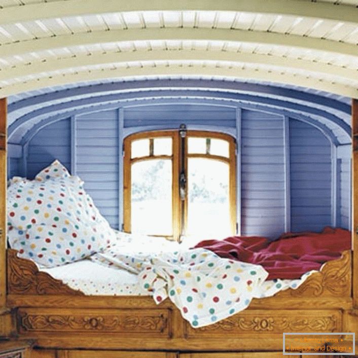 Minimalne podrobnosti v spalnici v rustikalnem slogu. Oblikovalec je izbral nenavadno mesto za posteljo. Mala postelja, ki je na oknu, je idealna postelja za sanjarje.