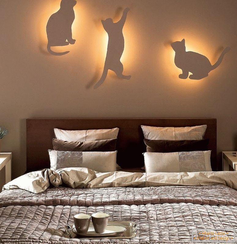 Mačke z lučmi na steni