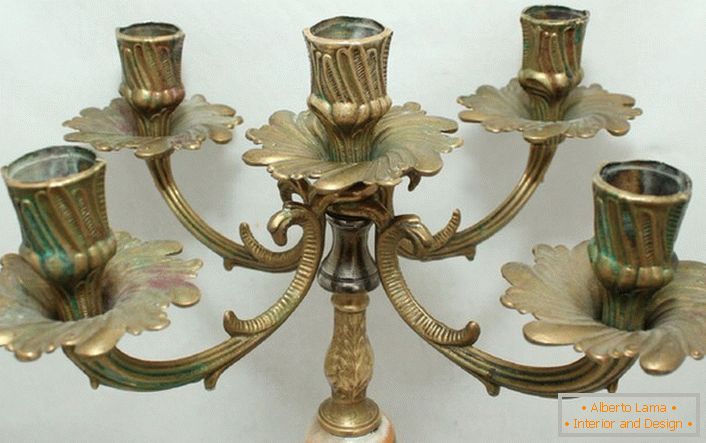 Stilski kandelabrum iz medenine s cvetličnimi motivi harmonično je napisan v notranjosti v slogu države.