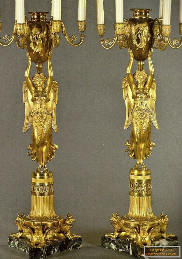 Par enake zlate kandelabre okrasi spalnico v baročnem slogu. 