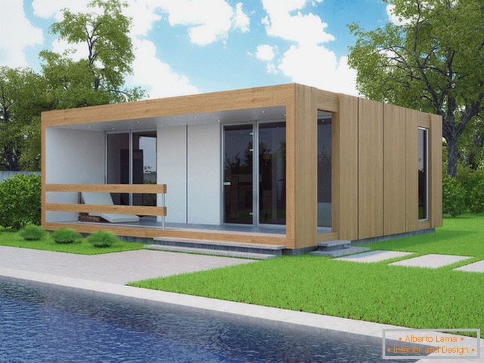 Majhna modularna hiša z bazenom na dvorišču. Eleganten dizajn hiše, ki se gradi hitro, je organsko videti na ozadju kratke posejane trate.