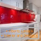 Bela pohištvo in rdeča platišča v notranjosti kuhinje