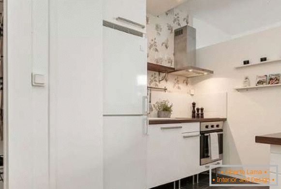 Zasnova majhne kuhinje v notranjosti studia stanovanja v belih tonih