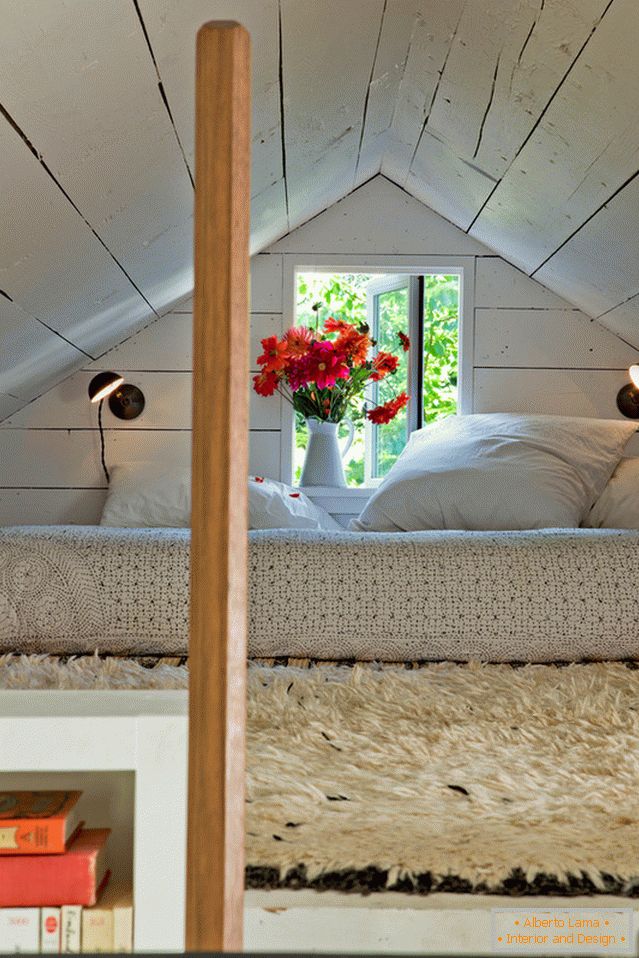 Spalnica pod stropom v majhni udobni hiši