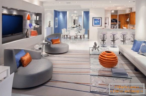 Kombinacija oranžne in modre v sivi dnevni sobi