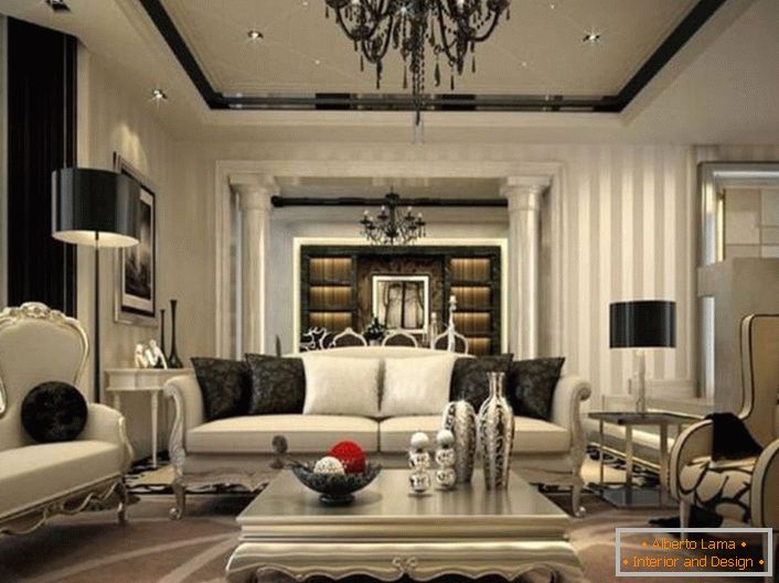 Izvrstna notranjost dnevne sobe je premišljena v neoklasičnem slogu. Črni elementi dekoracije in dekoracije so vidni v ozadju bledih sivih odtenkov.