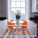Oranžni stoli v sivi notranjosti kuhinje
