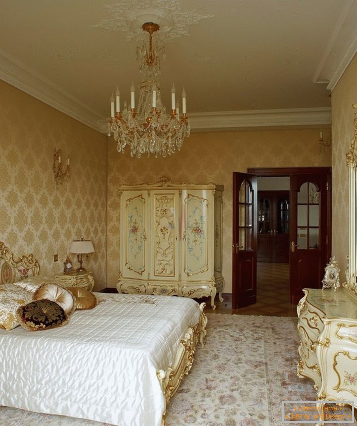 Eleganten lestenec in strop s štukatno mešano skladno z lesenim pohištvom v zlati barvi. 