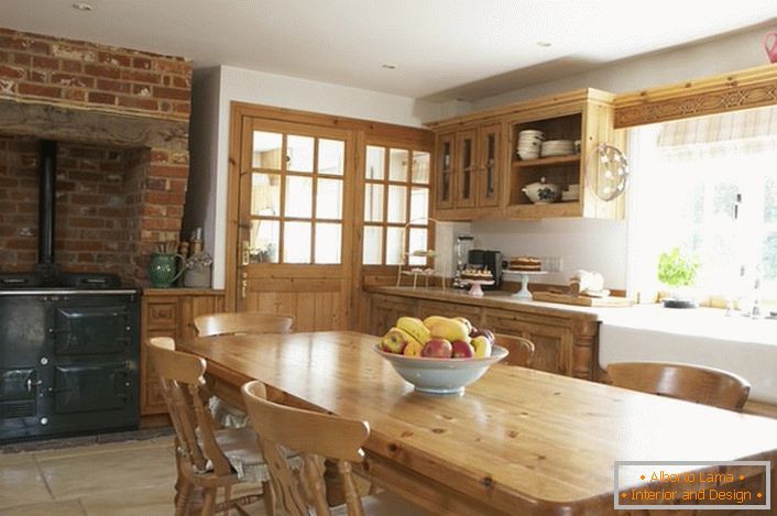 Prostorna kuhinja v deželi. Leseno pohištvo in dekoracija opeke preko peči dajejo slog naraven in romantičen.