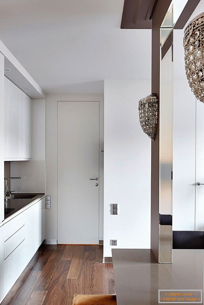 Bela kuhinja pohištvo, bela vhodna vrata in lep leseni parket