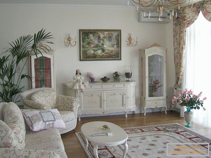 Prostorna dnevna soba je urejena v romantičnem slogu v svetlih barvah.