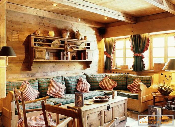 Lesena stenska dekoracija, kontrastne blazine na mehkem kavču, gosto zavese z ruffle na oknih. Udobna dnevna soba v rustikalnem stilu v deželi.