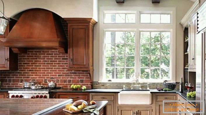 Pravilno urejena kuhinja v rustikalnem slogu. Kuhinjske in temne lesene omare so kombinirane s steno, ki je iz opeke.