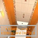 Kombinacija bele in oranžne ploščice v oblikovanju stranišča