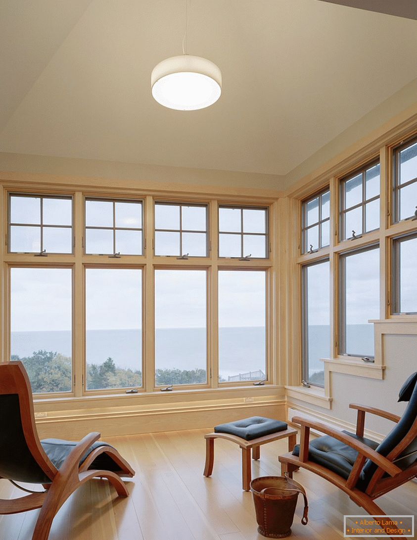 Idealna dnevna soba z velikimi okni in lesenimi tlemi