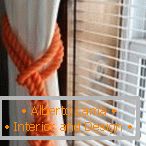 Bela zavesa in oranžna vrv