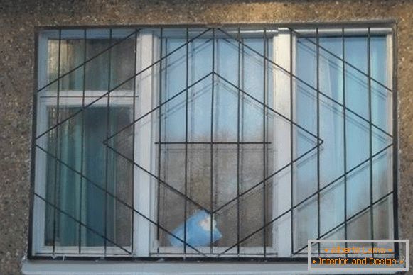 Varjene kovinske rešetke na oknih - fotografija iz fasade
