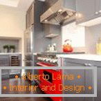 Sivo pohištvo in rdeči štedilnik v kuhinji