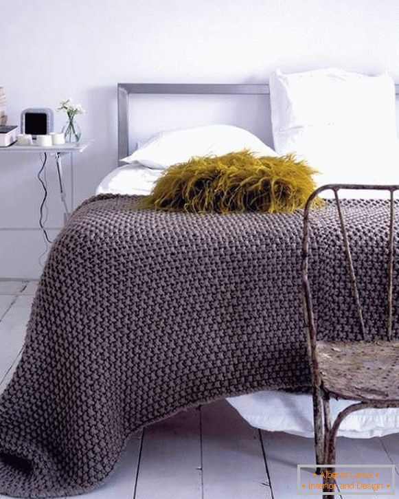Pletena pletena na postelji s svojimi rokami v modi barvi