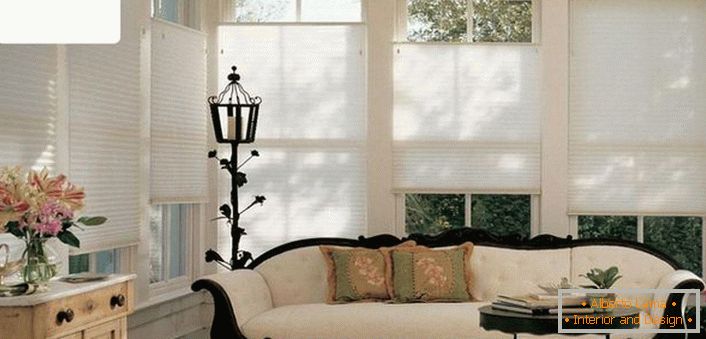 Sodobne enobarvne, zračne zavese, ki so prevlečene, ne preobremenijo prefinjenega vzdušja dnevne sobe stare hiše. 