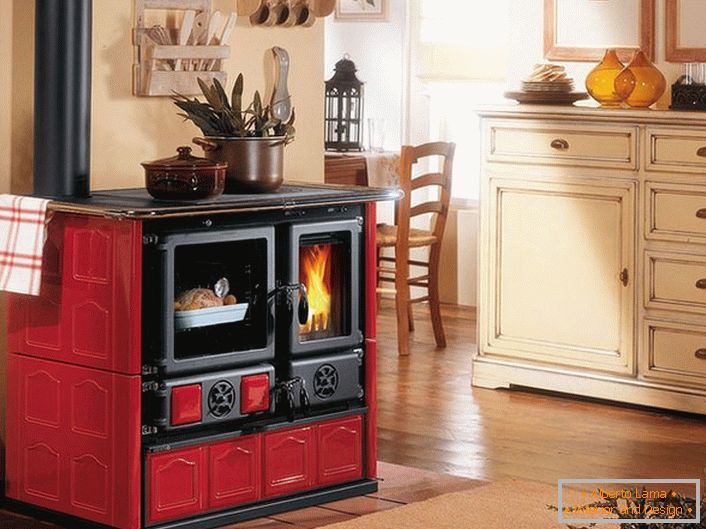 Kamin v rdečih in črnih barvah je dekoracija kuhinje v slogu Provence.